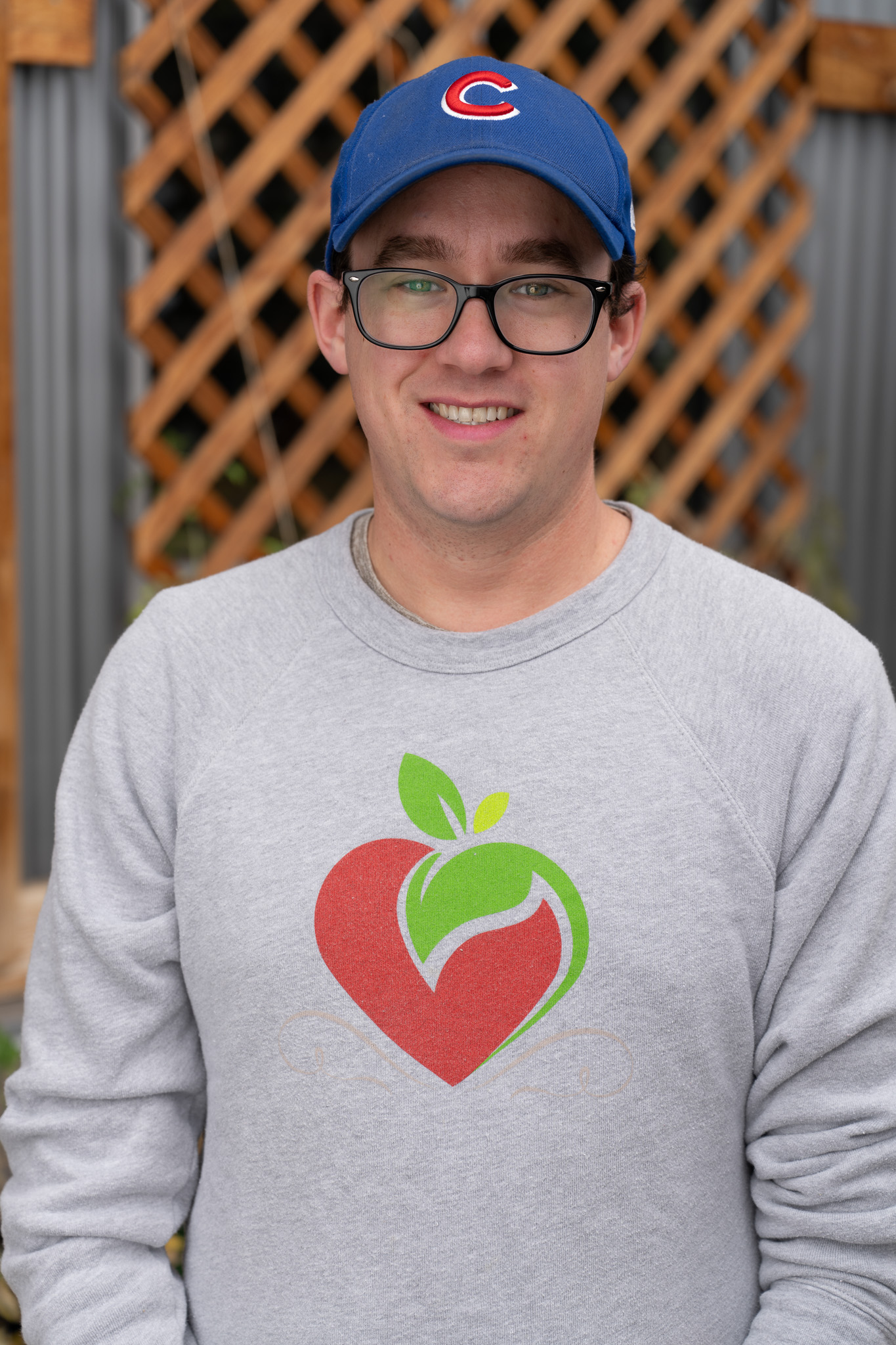 Andrew Borg's headshot. He is wearing his signature Cubs ballcap and a Metro Caring sweater.