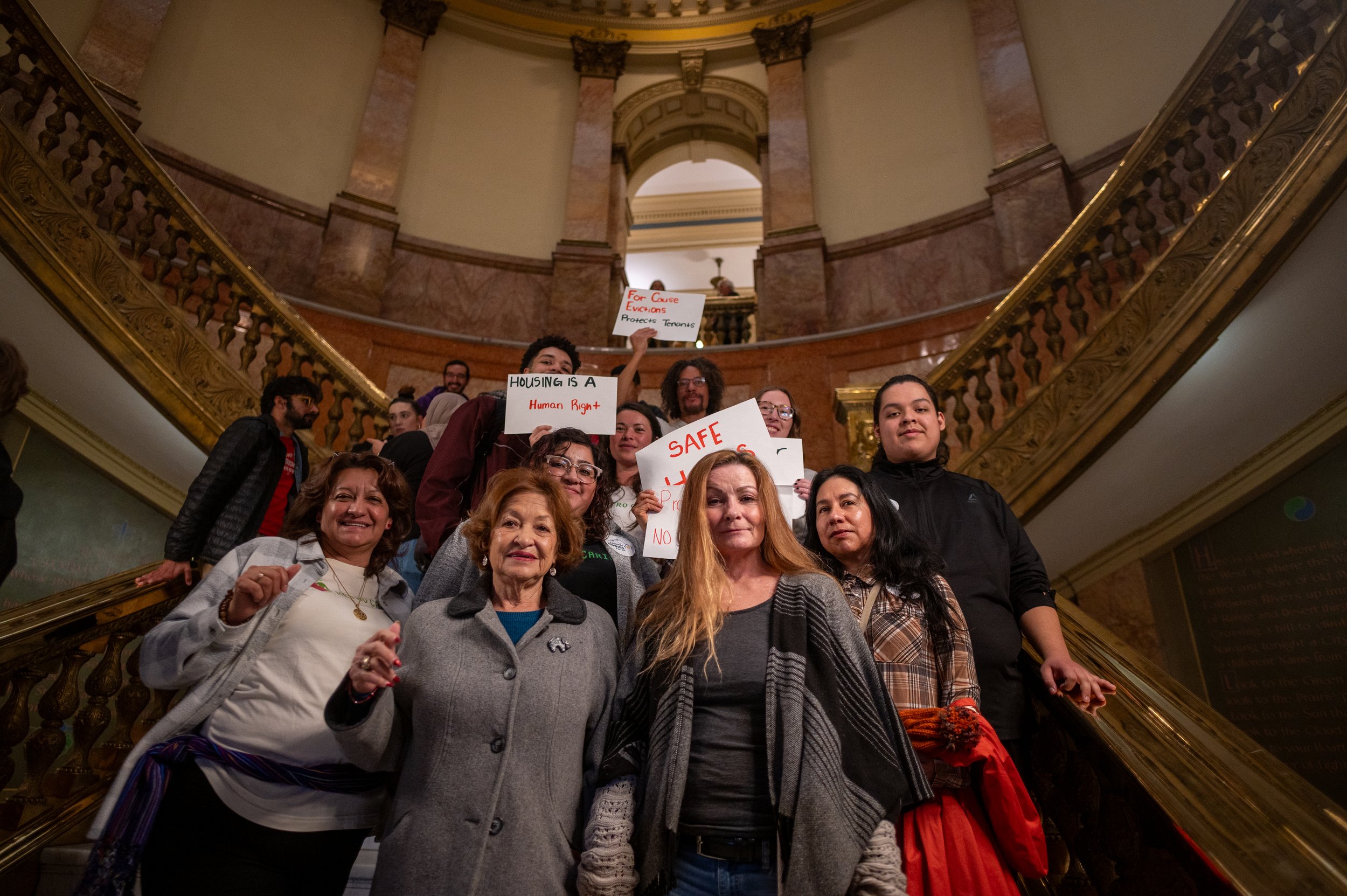 Metro Caring Staff, Intern,s Community Organizers Standing on the steps of the Capital holding signs