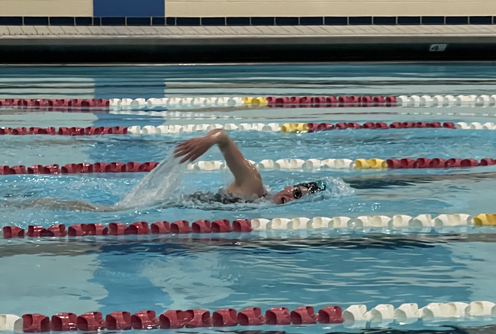 Sophia comes up for air mid-stroke as she swims across an Olympic sized swimming pool. 