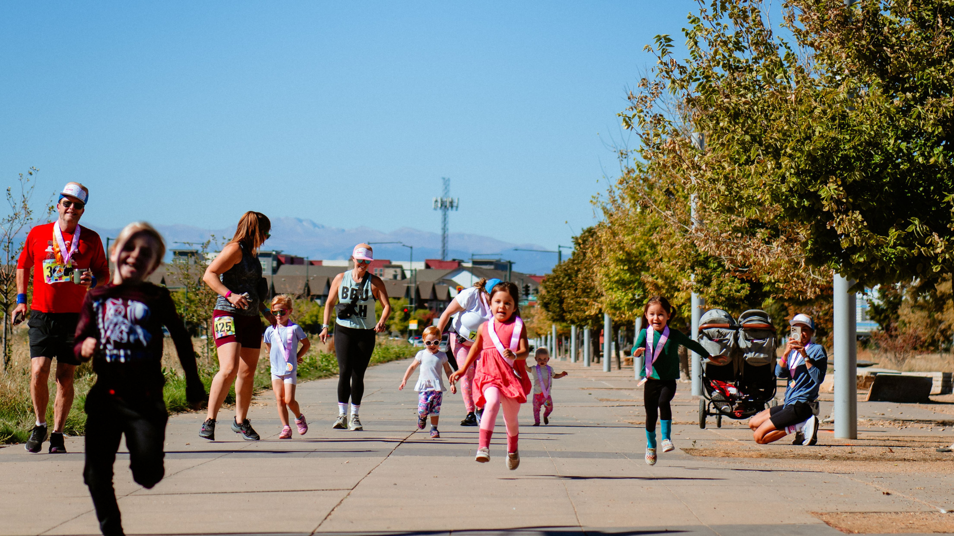 Toddlers and adults run towards the camera while at the Brunch Run in 2023 at Central Park.