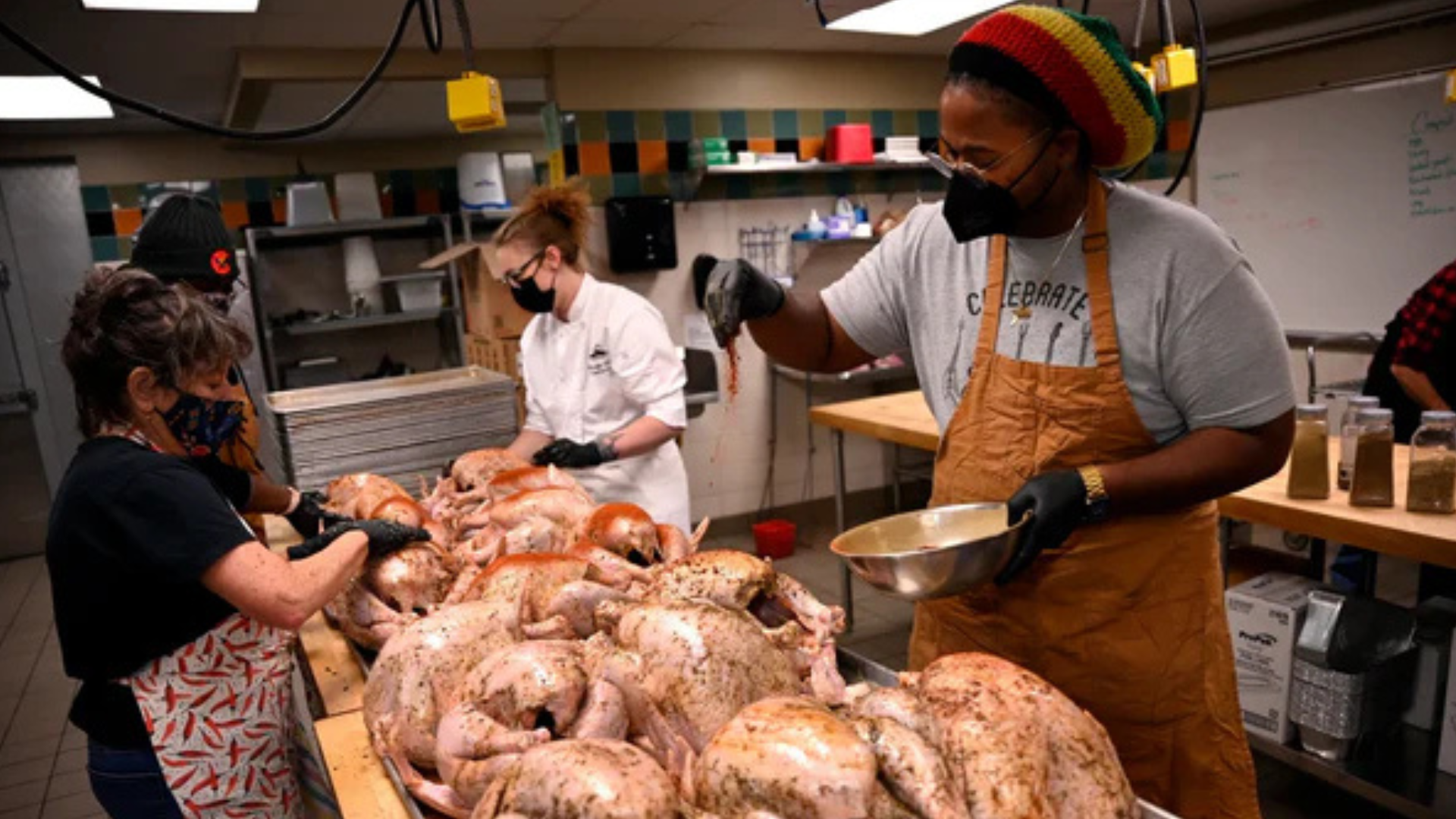 Chef sprinkles seasoning on about 8 turkeys.