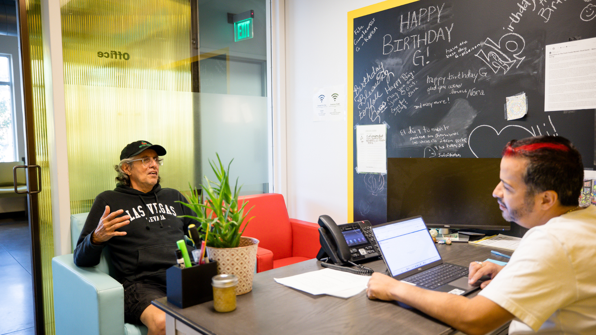 Two people talk in one of Metro Caring's offices.