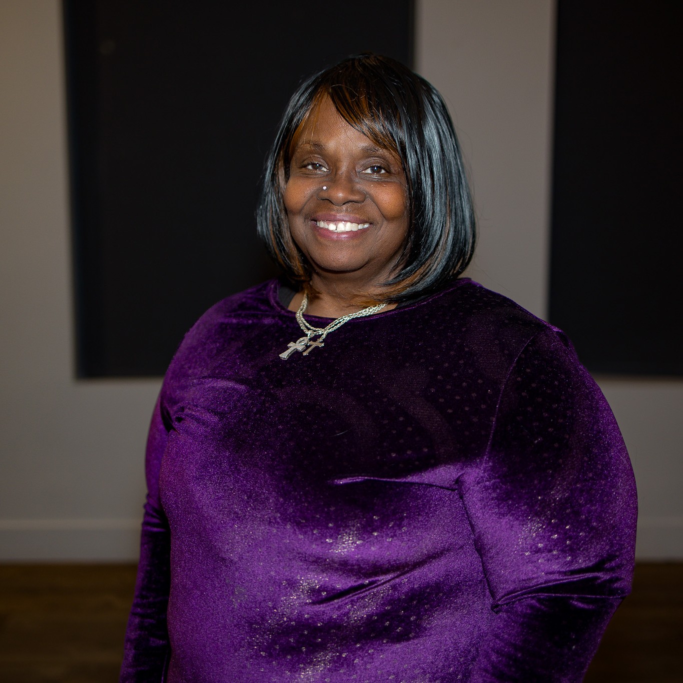 Elaine smiles at the camera wearing a shimmering purple dress.