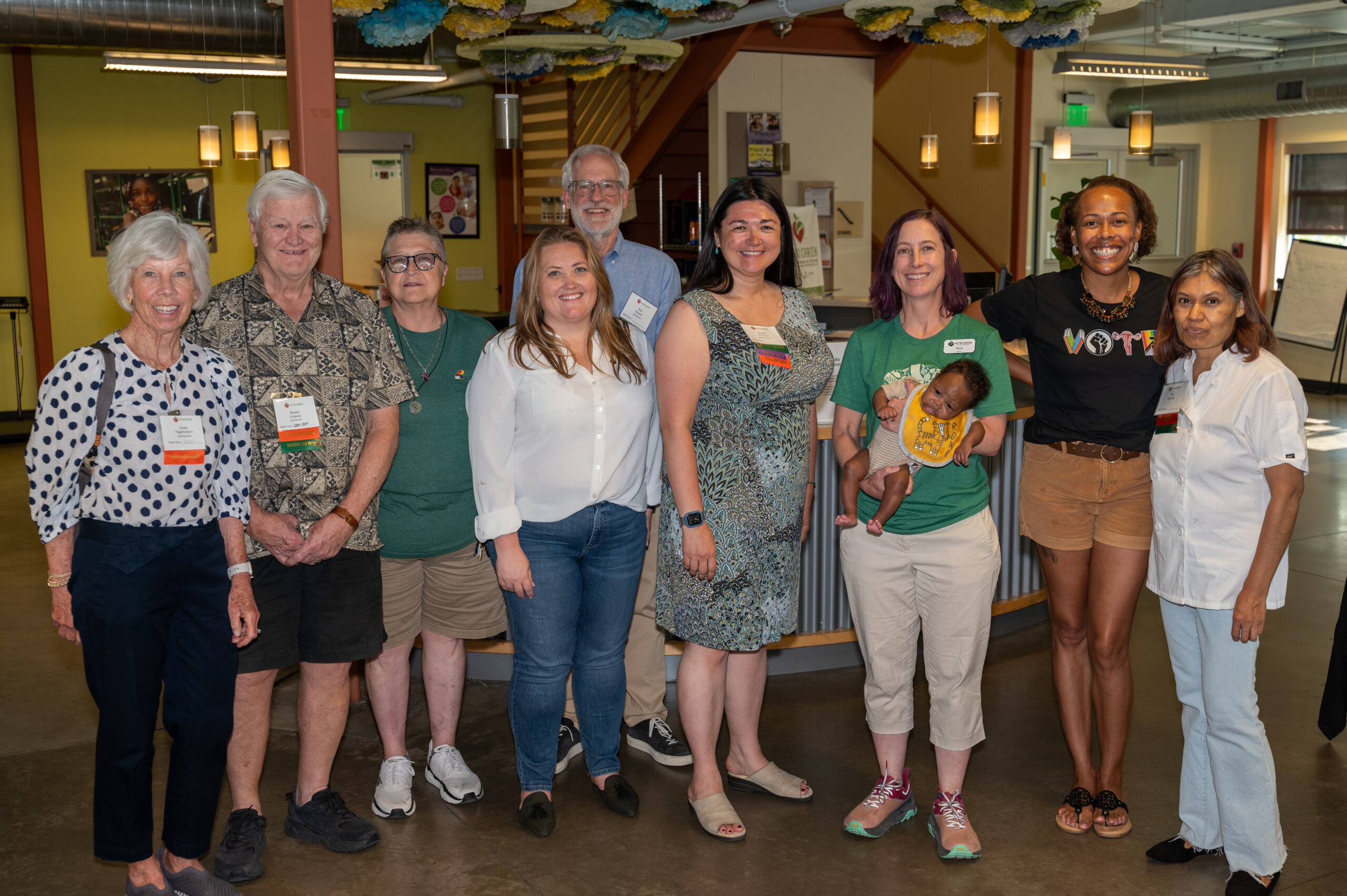 Group photo of current and former Board members in Metro Caring's welcome center. 