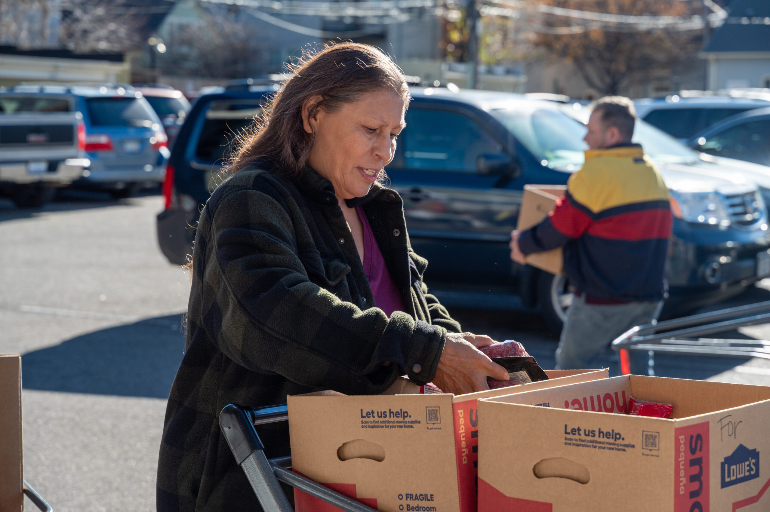 Woman packing a meat in a donated food box